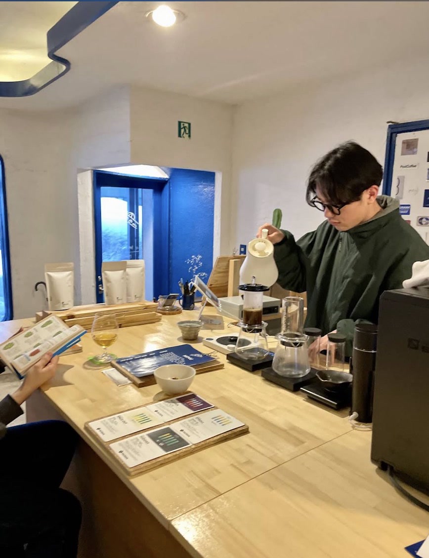カウンターでコーヒーを淹れる店主と、くつろぐお客さん